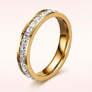 Macro detail of a gold titanium steel eternity ring with channel-set clear stones.