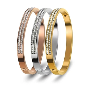 Detail showing triple-color stainless steel bangles with luxury pavé-set crystals.