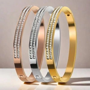 Detail of three stainless steel bangles with double rows of square crystals in assorted colors