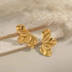 Boucles d'oreilles dorées forme papillon aux plis organiques sur plateau en pierre