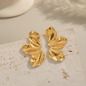 Boucles d'oreilles pétales en acier titane doré sur un support en pierre naturelle