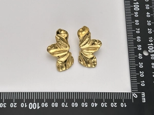 Vue détaillée des boucles d'oreilles papillon dorées avec texture de pétale froissée