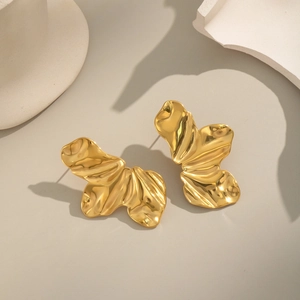 Vue détaillée des boucles d'oreilles papillon dorées avec texture métallique plissée