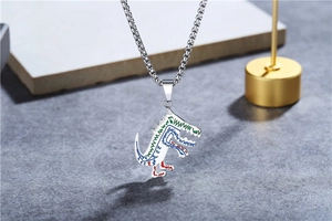 Gros plan du collier pendentif dinosaure en acier titane avec émail coloré sur support