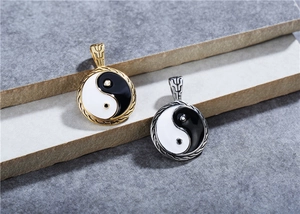 Detailed macro view of gold and silver Yin Yang pendants with black and white enamel finish