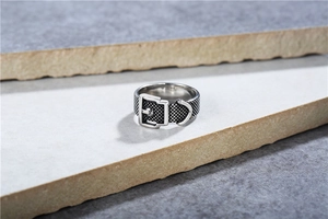 Macro detail of retro belt buckle ring featuring punk texture and oxidized silver finish