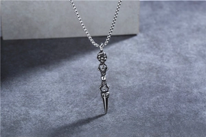 Detailed view of vintage Vajra pestle pendant with intricate Buddhist carvings in steel
