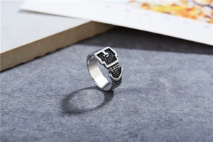 Macro detail of vintage belt buckle ring with embossed texture and rustic black finish