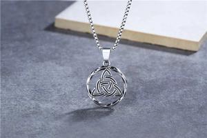 Macro detail of vintage Celtic Trinity Knot pendant in oxidized stainless steel finish