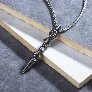 Retro stainless steel vajra pendant necklace with skull detail on a stone surface