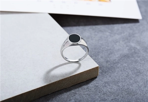 Détail de la bague ovale en acier titane avec émail noir et finition argentée polie