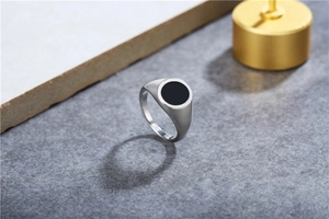 Vue détaillée d'une bague chevalière en acier inoxydable argenté avec un cercle noir poli