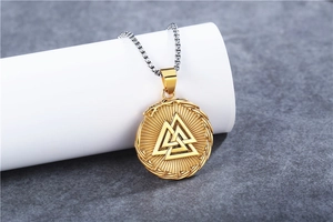 Macro shot of gold Valknut pendant with Nordic knotwork on silver chain necklace