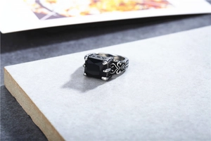 Detailed macro view of retro gothic silver steel ring with square black gemstone and carvings