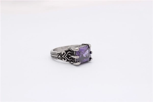 Detailed close-up of vintage steel ring featuring square purple stone and carved patterns