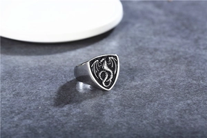 Detailed macro view of vintage gothic shield ring featuring a 3D dragon relief carving
