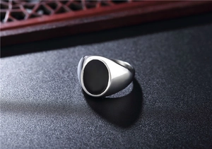 Macro shot of silver men's signet ring with a polished black oval inlay detail