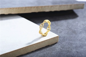 Macro shot of gold DNA double helix ring standing on minimalist stone texture background