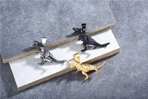 Macro detail of textured dinosaur skull pendants in gold, black, and silver finishes