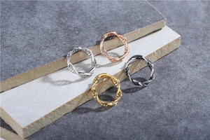 Close-up of four DNA helix hollow rings in silver, rose gold, gold and black gray