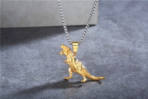 Close-up of golden Tyrannosaurus Rex pendant necklace with detailed scales on box chain