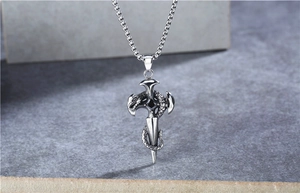 Detailed view of retro snake and sword cross pendant on a square pearl necklace chain
