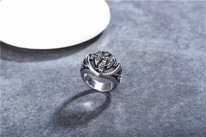 Détail macro du relief d'ange religieux et gravure grecque sur la bague en acier