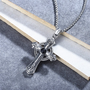 Retro gothic cross pendant necklace for men with black gemstone and box chain on stone surface