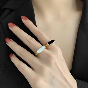 French style geometric gold rings with black and white shell inlays on model
