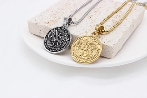 Primer plano de medallas de San Miguel en oro y plata con cadenas de eslabones
