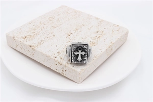 Macro view of vintage stainless steel cross ring with oxidized black finish on stone base