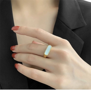 Minimalist gold titanium steel ring with white shell inlay worn on index finger