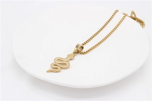 Detailopname van de gouden slangenhanger met schubstructuur aan een fijne box-schakelketting