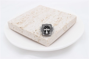 Detailed close-up of retro silver cross ring with black oxidation on stone block