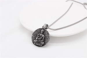 Vista dettagliata del ciondolo Buddha in argento antico su un piatto in ceramica