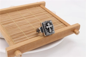 Macro detail of vintage stainless steel cross ring with antique finish on bamboo mat