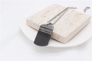 Gros plan du pendentif rectangulaire gris anthracite avec texture en métal brossé et chaîne