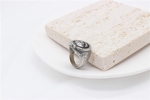 Macro detail of retro Egyptian Eye of Providence ring with hammered texture on white stone