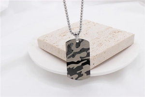 Détail d'un pendentif camouflage militaire sur chaîne à billes en acier titane