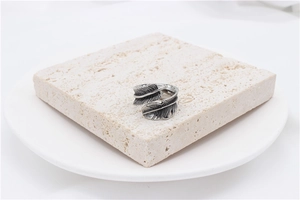 Detailed close-up of retro feather ring with intricate textures on stone display