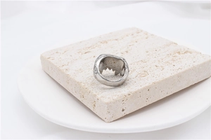 Detailed close-up of retro monster claw titanium steel ring on a textured stone base
