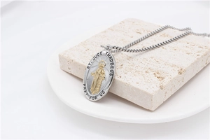 Macro view of St. Jude Thaddeus oval pendant necklace with two-tone finish and engraving