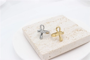 Detailed view of polished gold and silver Ankh cross rings on a stone display