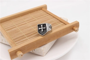 Detailed shot of retro rock shield ring with cross emblem on a rustic bamboo mat