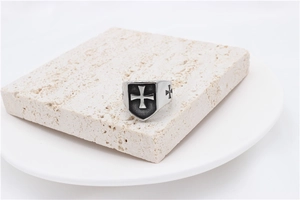 Detail of vintage shield ring with cross engraving on polished stainless steel
