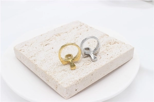 Detailed view of gold and silver Ankh cross rings displayed on a natural stone base