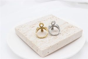 Detailed close-up of gold and silver Ankh cross rings on a textured stone block