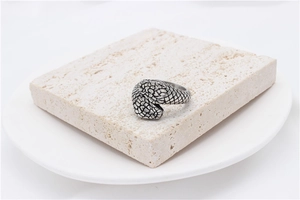 Detail view of vintage silver snake scale texture on a minimalist steel band ring