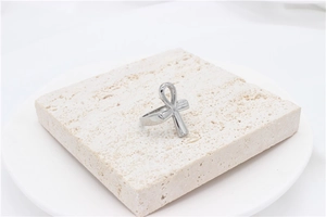 Macro shot of silver stainless steel Ankh cross ring on natural travertine stone