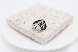 Macro detail of men's gothic steel ring featuring Maltese Cross and black enamel inlay